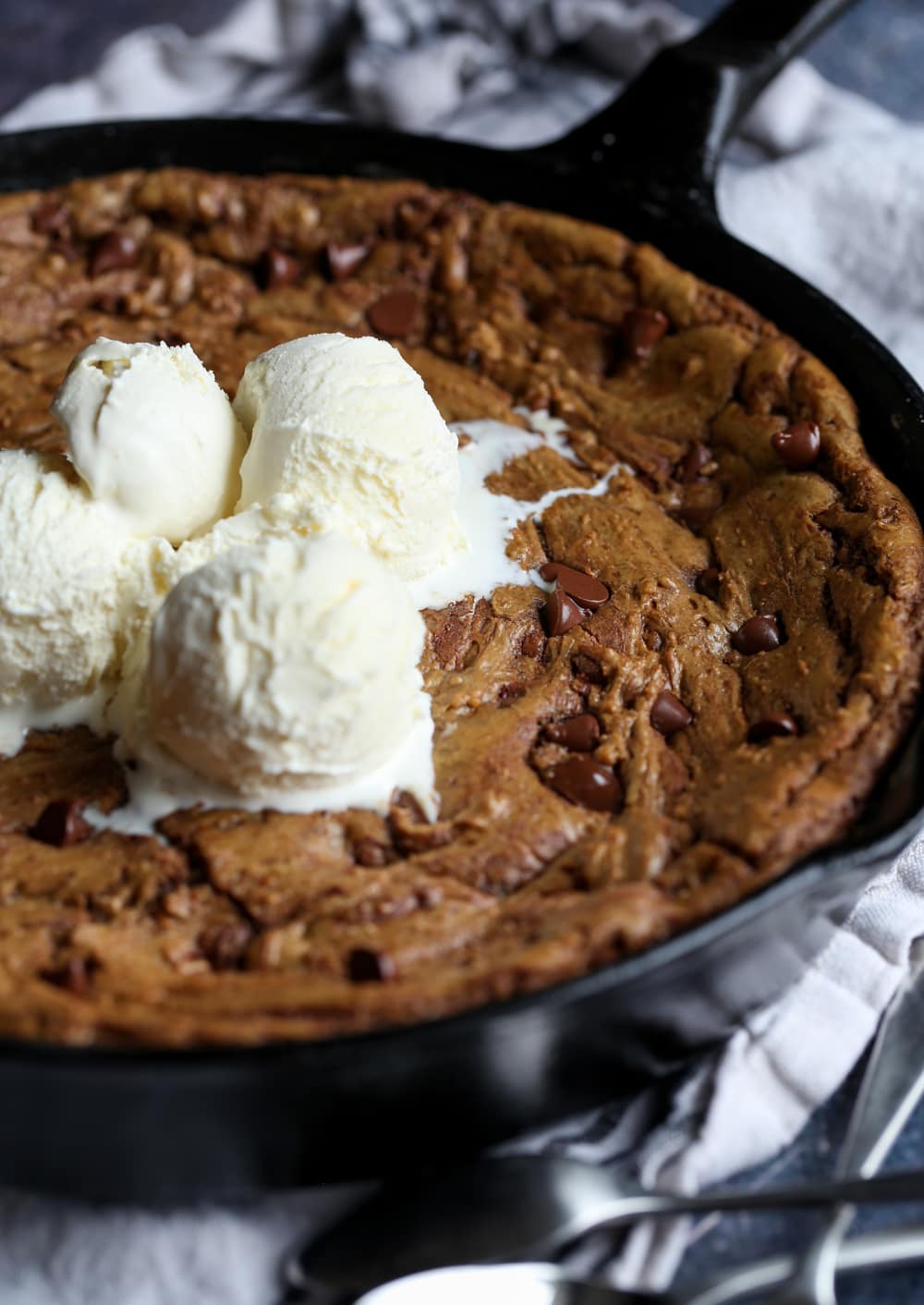 Pizookie topped with melted ice cream in a skillet