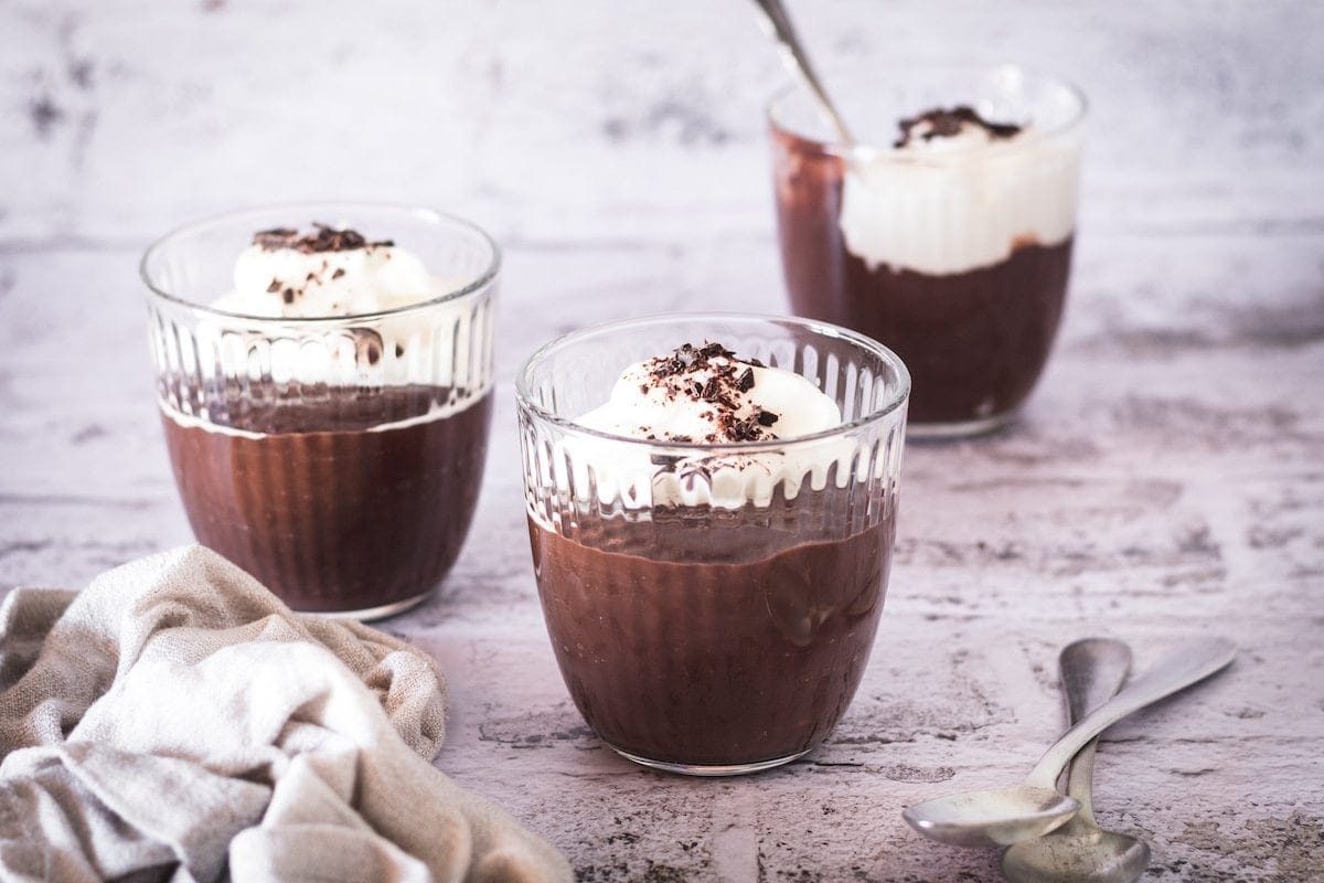 Three cups of pudding with cream.